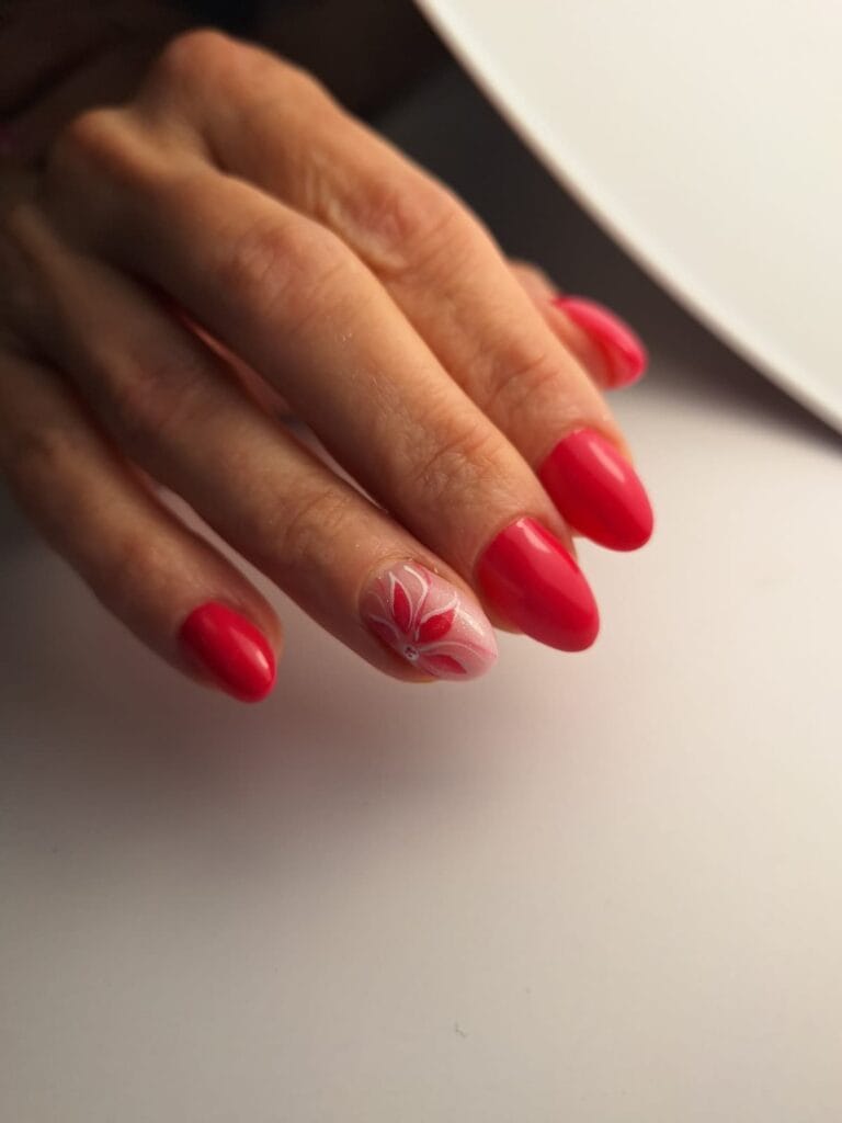 Czerwony manicure z ręcznie malowanym kwiatem