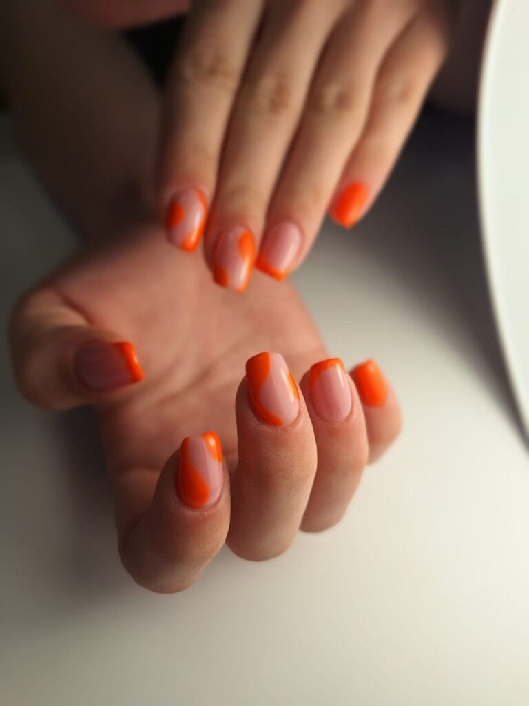 Pomarańczowy manicure z artystycznym wzorem – stylizacja na lato
